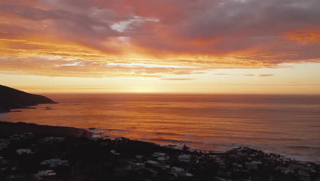 sunset in coastal town in bakoven, cape town, south africa - aerial shot