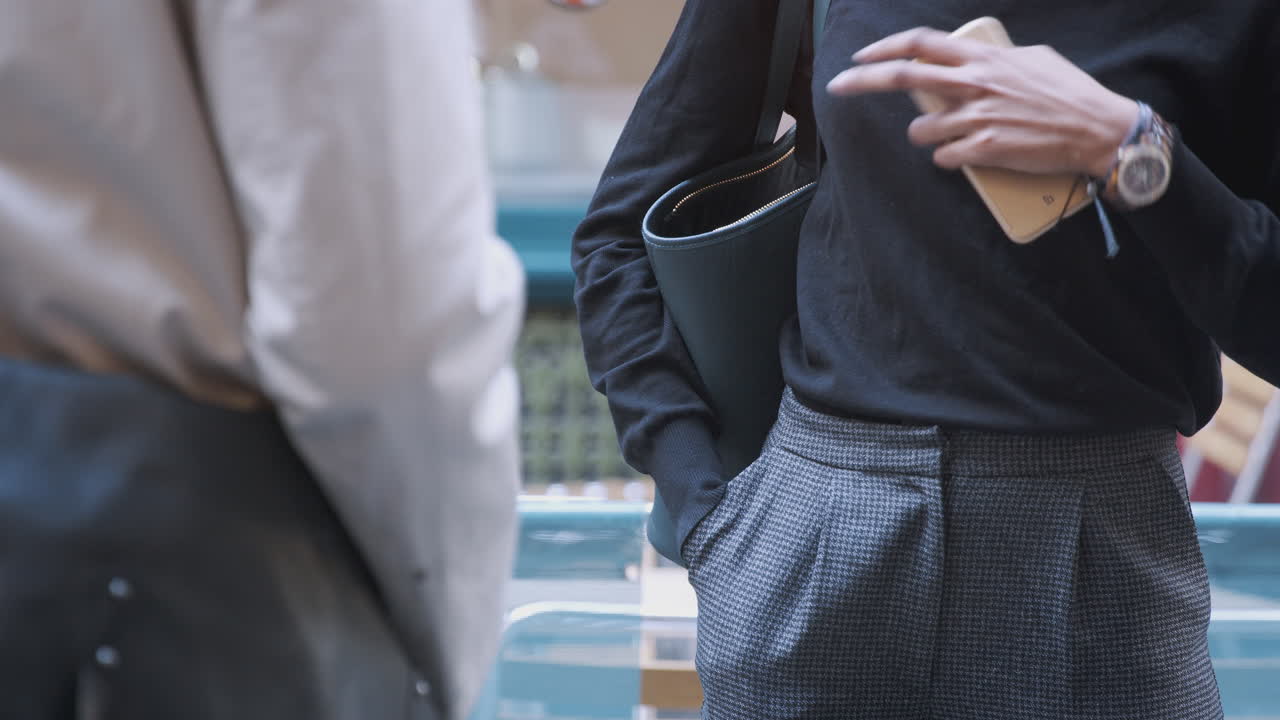 길거리에서 대화를 나누는 두 명의 똑똑하고 캐주얼한 옷을 입은 밀레니얼의 중간 섹션, 클로즈업, 선택적 초점