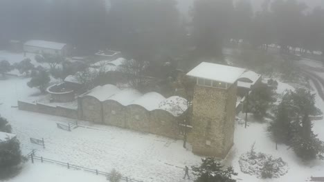 snowy mountaintop building with foggy landscape