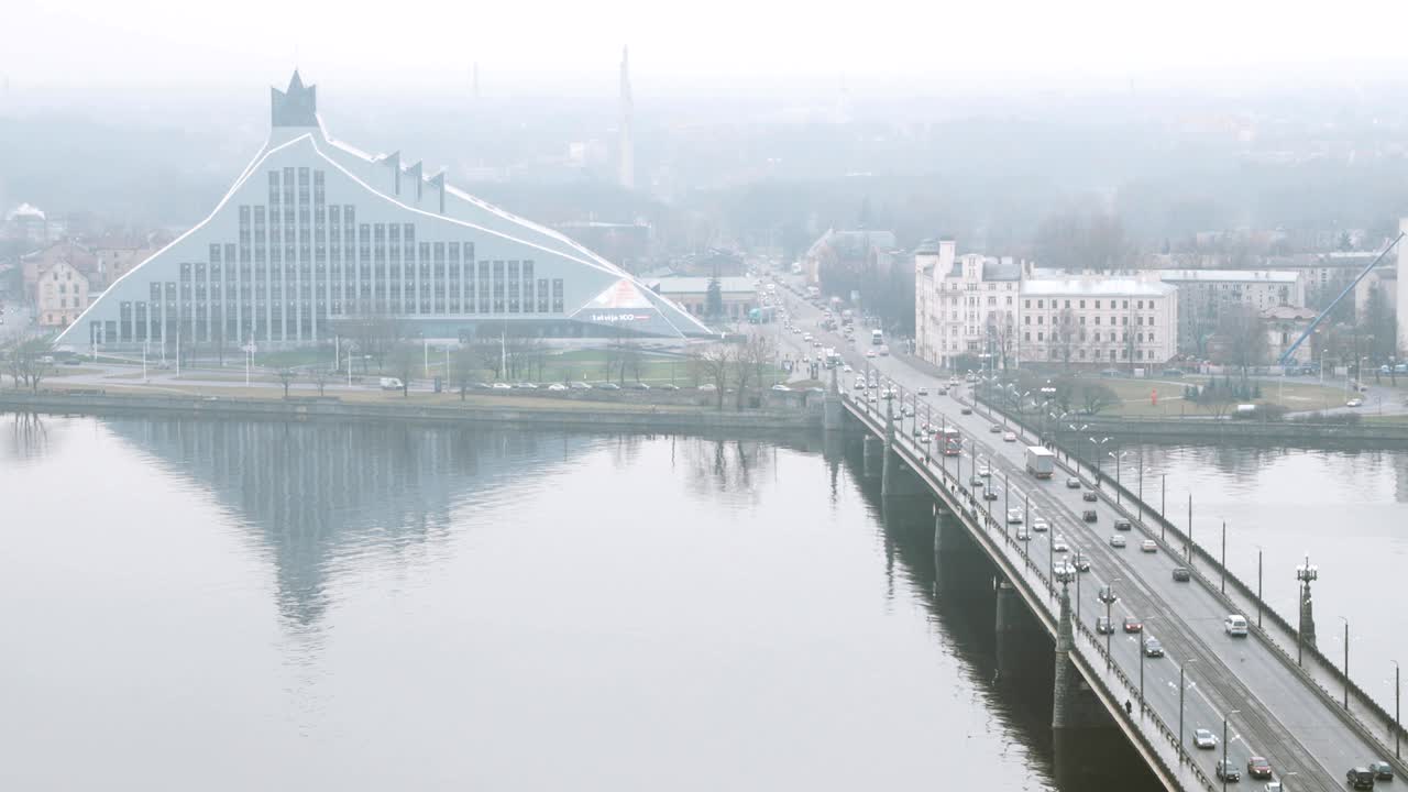 리가, 라트비아 - 2017 년 12 월 19 일: 아크멘스 트 (akmens tilt) 의 상단 전망 교통 - 안개와 비가 오는 겨울 날에 돌 다리와 국립 도서관 건물. 다우가바 의 유명한 랜드마크