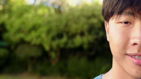 Smiling boy with braces enjoying outdoor time in green garden setting, copy space