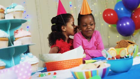 Girl-whispering-secret-to-her-friend-during-birthday-party-4k