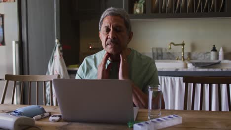 Senior-mixed-race-man-having-online-medical-consultation-using-laptop