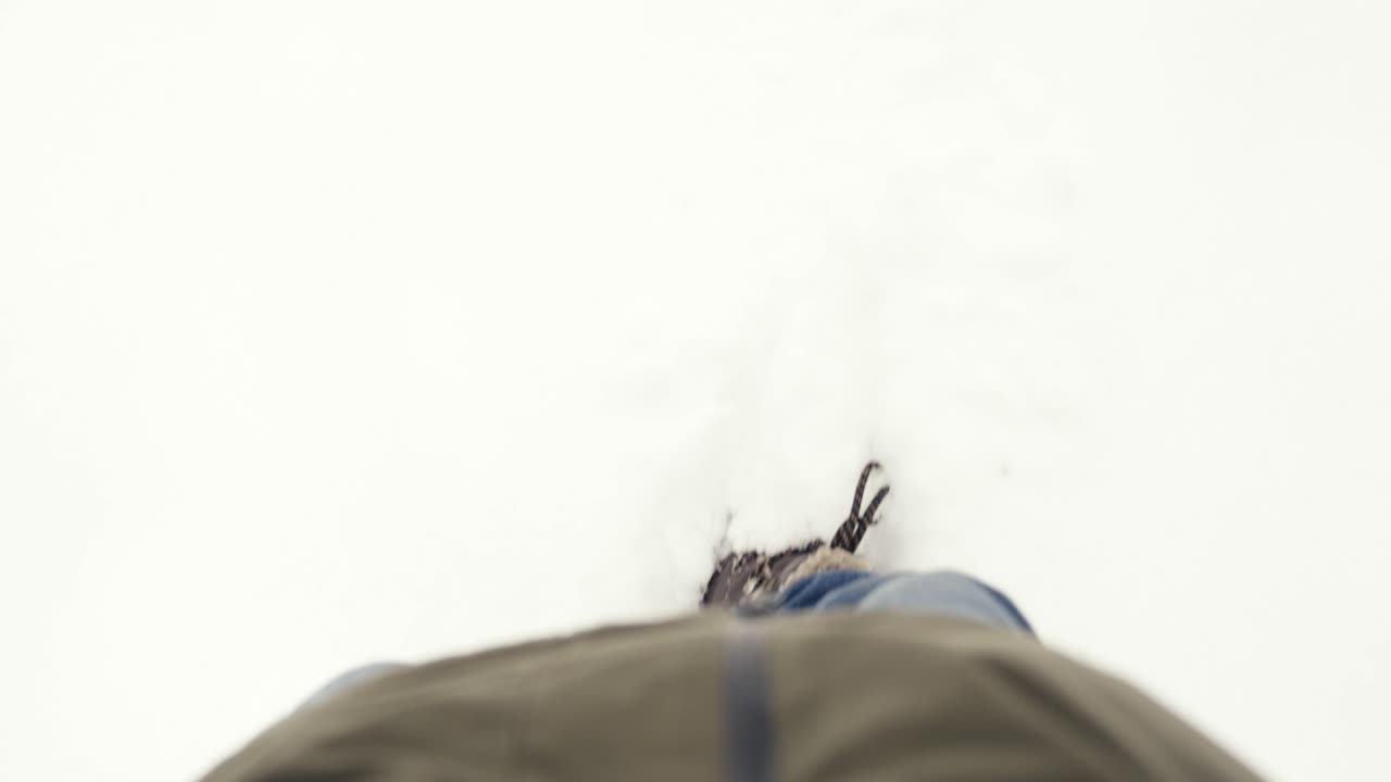 primer plano de los pies de una persona caminando en la nieve en cámara lenta