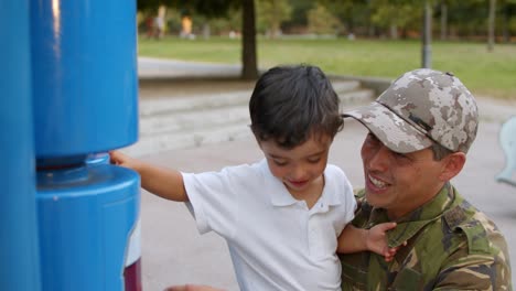 military daddy spending leisure time with little son in park