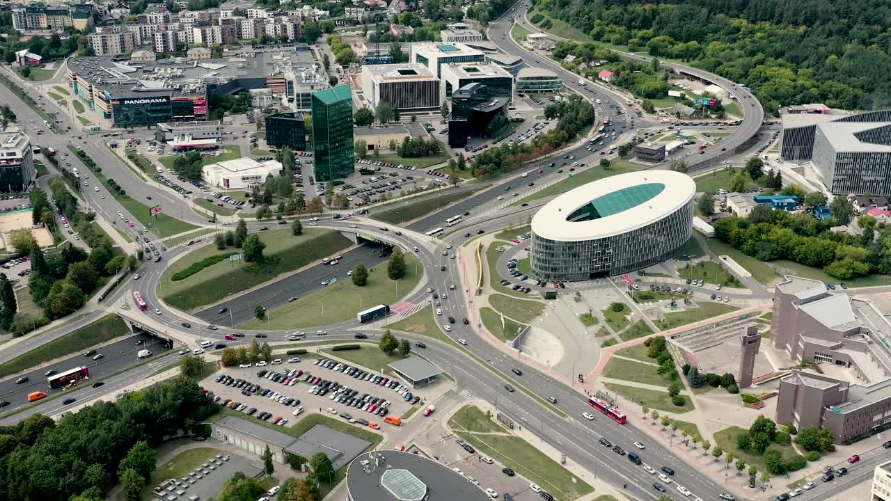 VILNIUS, LITUÂNIA - JULHO, 2019: Vista aérea do anel rodoviário e movimento circular no distrito comercial em Vilnius
