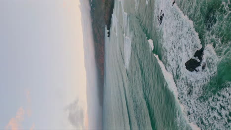 wonderful seascape coast washed by foamy ocean waves vertical view. stormy water