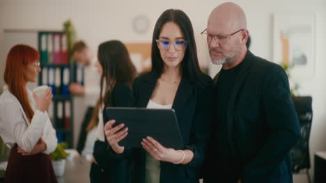 Employees-discussing-strategy-over-tablet-PC.