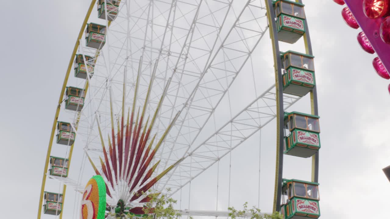 독일 슈투트가르트 발바리안 축제에서 빨간색 표지판 옆 관람차를 타고 있는 사람들, 일몰 시 유럽, 패닝 시야각