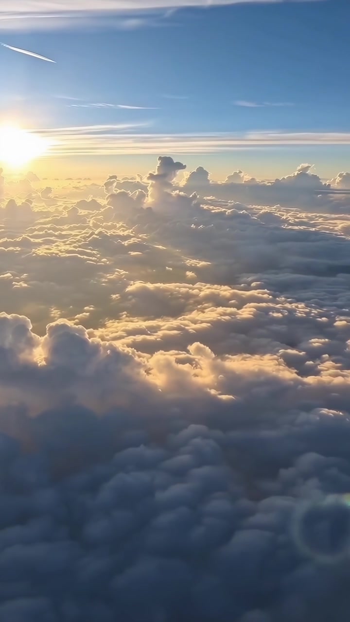 Tramonto dorato su una vasta distesa di nuvole dal finestrino dell'aereo