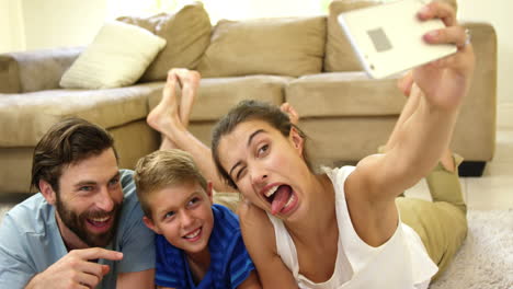 happy family lying on carpet taking a selfie