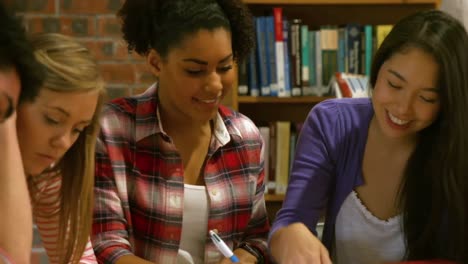 Compañeros-Sonrientes-Estudiando-En-La-Biblioteca.