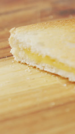 video of slices of toasted cheese white bread sandwiches on wooden chopping board background