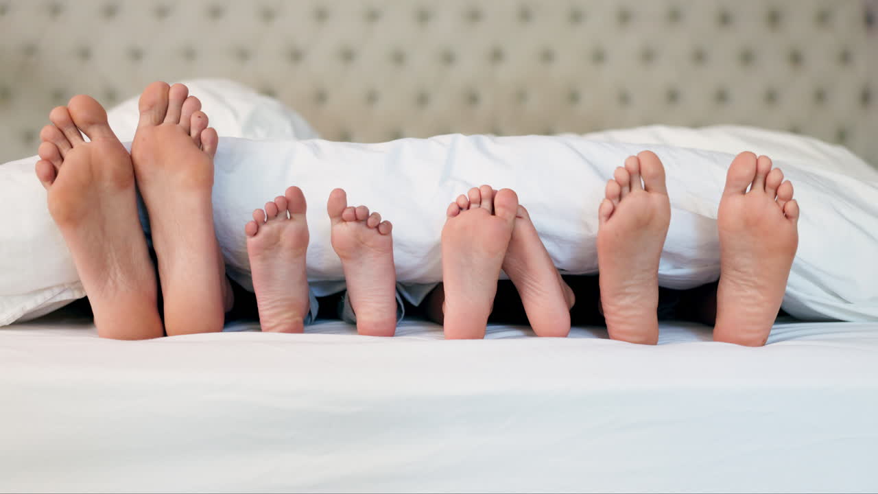 Cama, pies y familia relajada