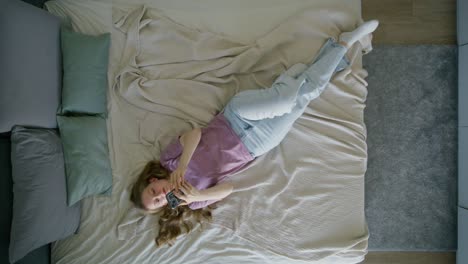 woman relaxing in bed with smartphone