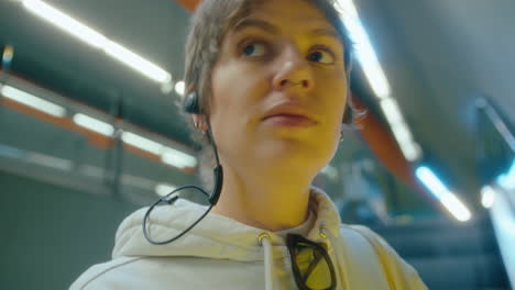 Woman in Earphones Riding Escalator in Underground