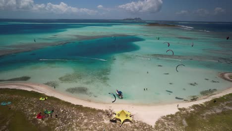 vibrant kite surfers at cayo vapor, los roques, venezuela, aerial view