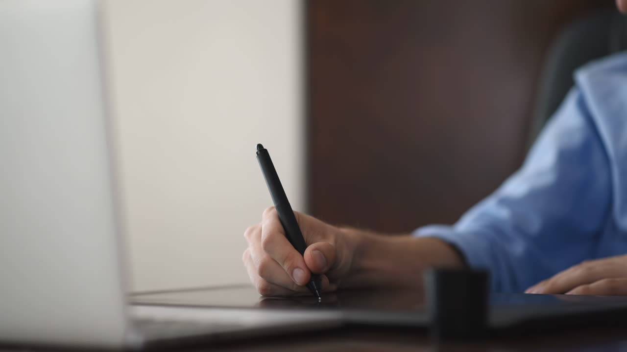 Man drawing on a pen tablet in the office. Close-up shot