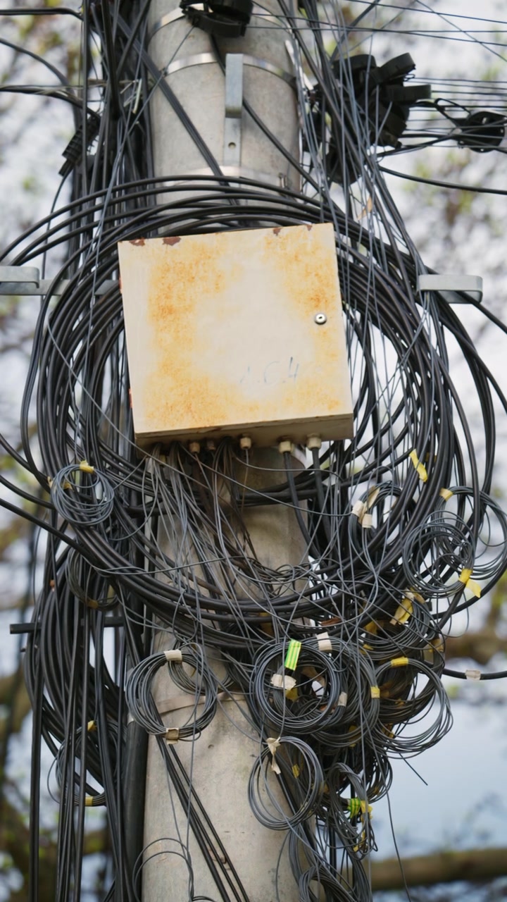 Close up of tangled cables and wires on a utility pole