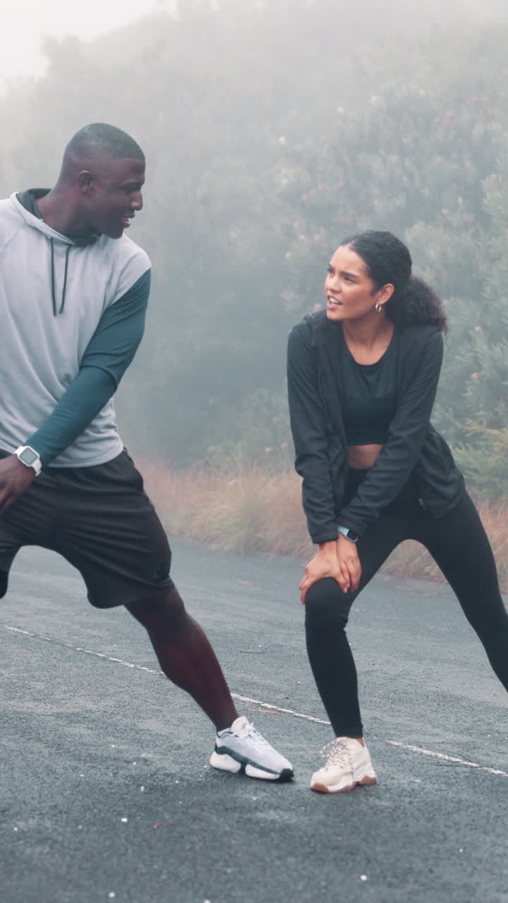 Happy Couple Stretching Outdoors on a Misty Morning Road