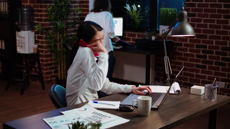 stressed employee doing multitasking, answering phone while crosschecking data