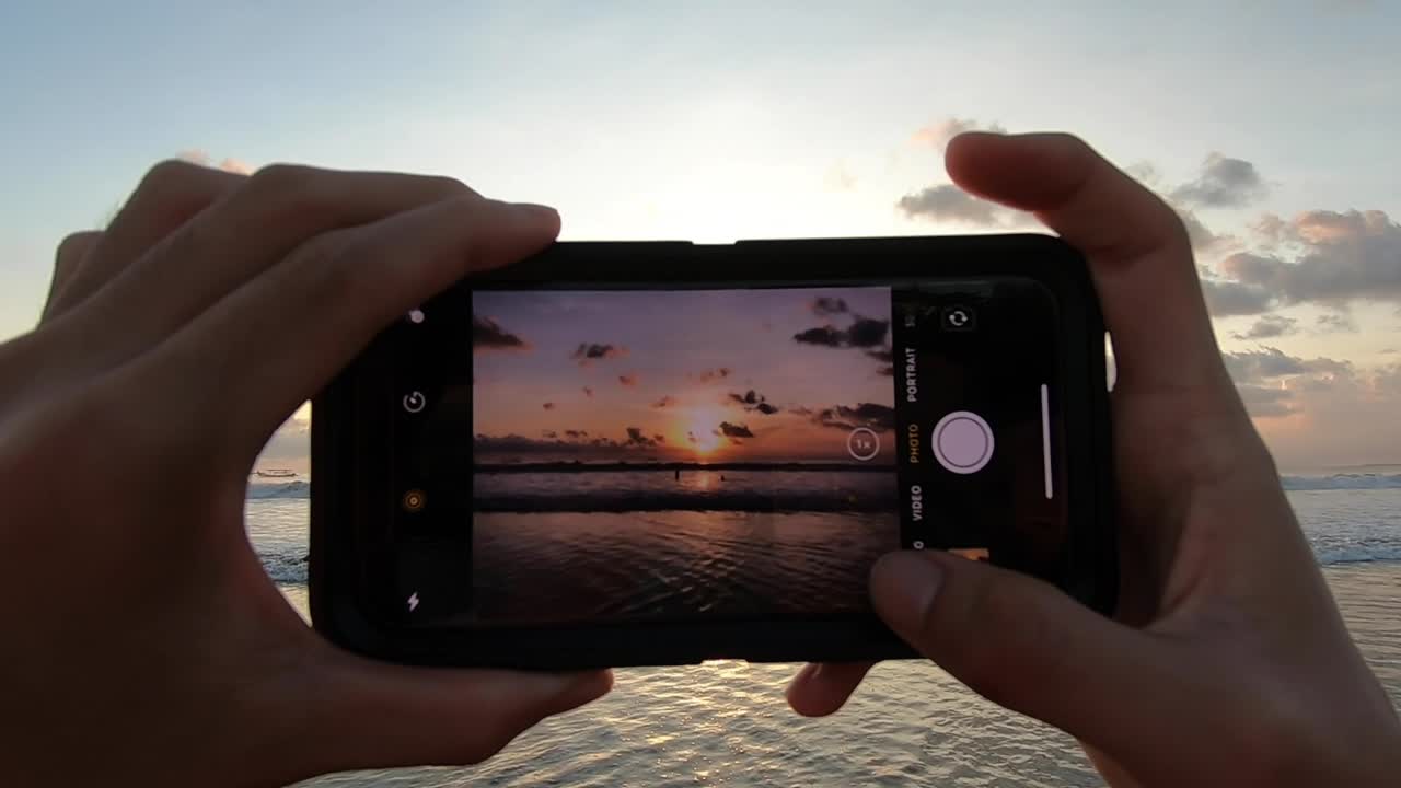 iPhone taking pictures of a sunset at a beach in Bali, Indonesia with sun setting
