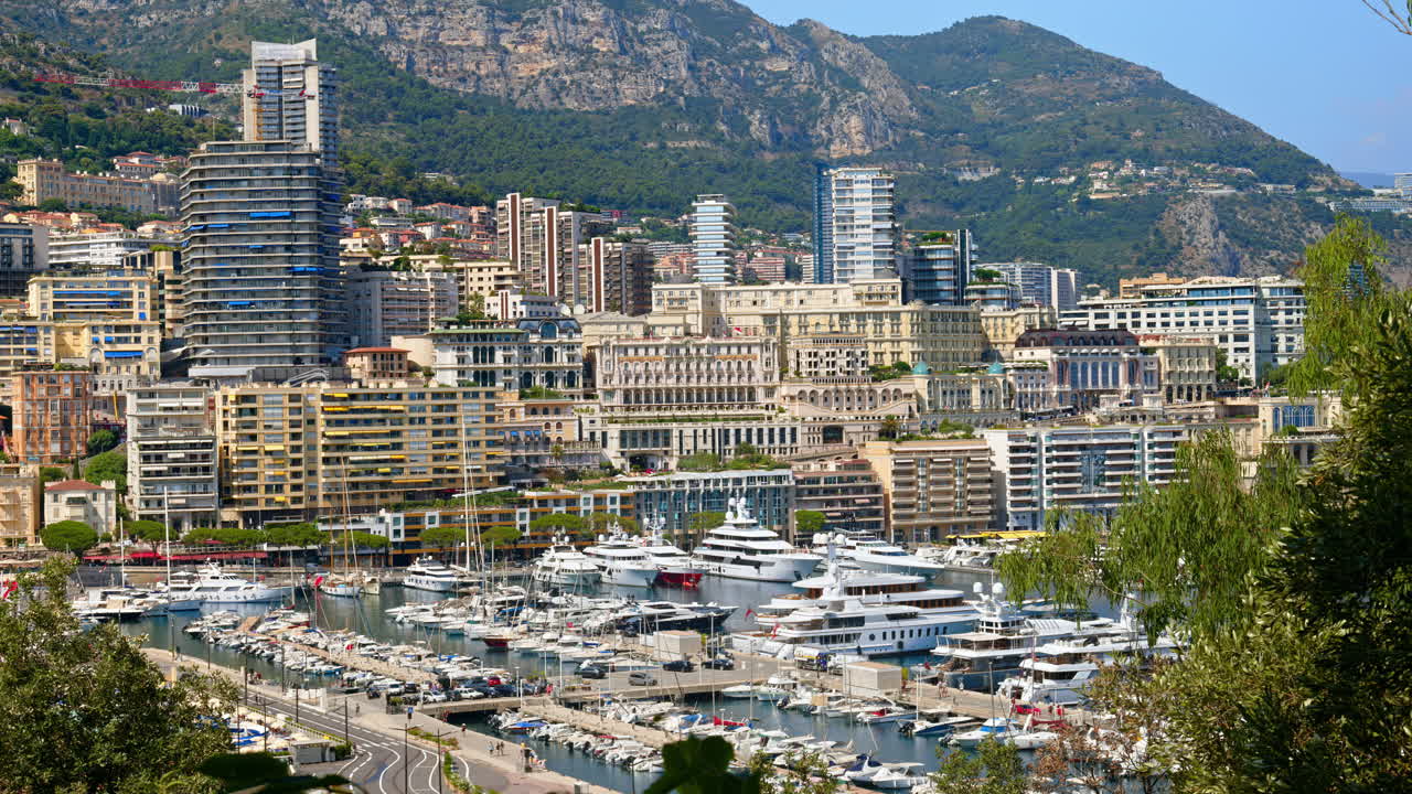 View of boats docked in the Monaco Marina with the skyline of the city on the background