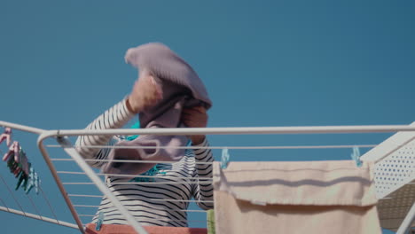 mujer secando ropa al aire libre