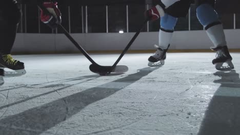 competencia de hockey sobre hielo, los jugadores están poniendo sus palos de hockey en la posición inicial alrededor de la pelota y comenzando el juego