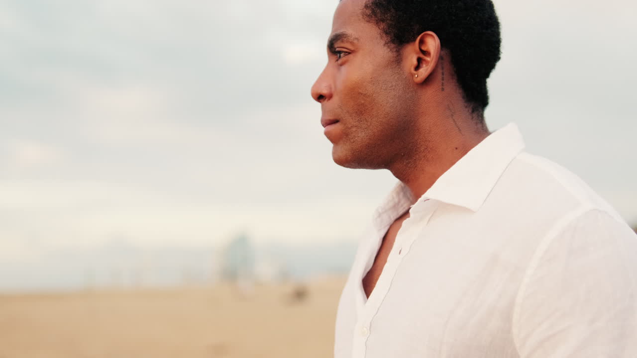 Pensive Young African American Man Looking at the Horizon on the Beach