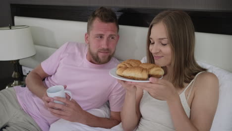 couple enjoying breakfast in bed