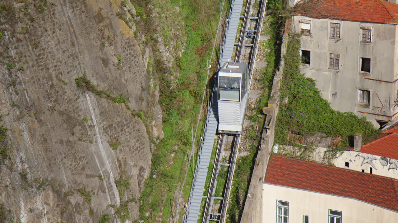 Guindais Funicular Moving Downhill On Steep Cliff In Porto, Portugal. high angle, tracking shot