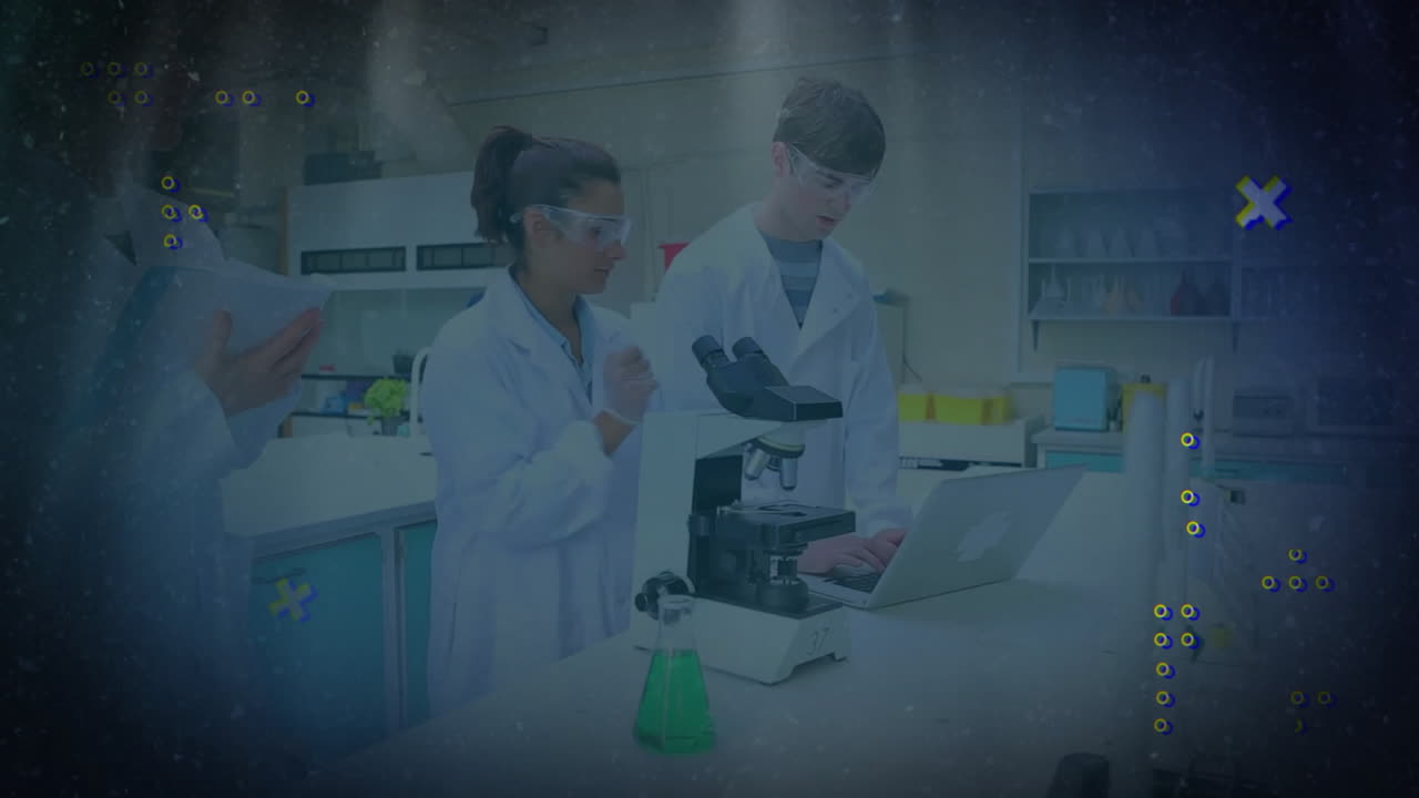 Lab researchers collaborating around microscope and laptop in tech lab, displaying animated graphs