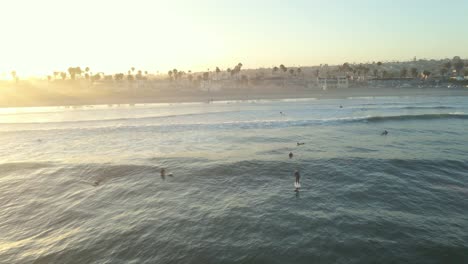 sunrise aerial shot circling surfers in ocean beach san diego california