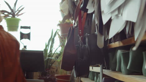 female shoemaker taking last from shelf in workshop