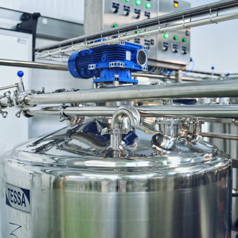 contemporary milk making factory indoors. huge bowls for mixing milk and water. special equipment for preparing cheese.