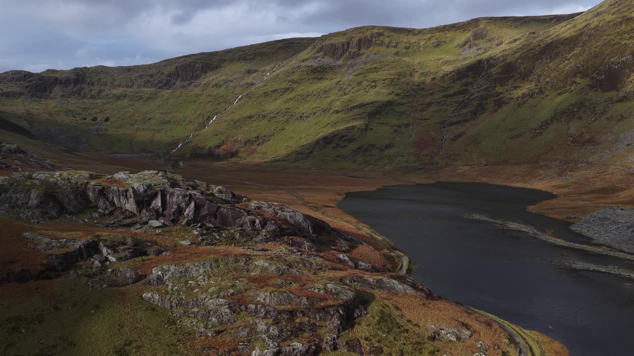 Picturesque view of Llyn Cwmorthin and Moelwyn Mawr in the Moelwynion range of Eryri National Park, showcasing a tranquil lake nestled within a dramatic landscape with historic slate mining ruins