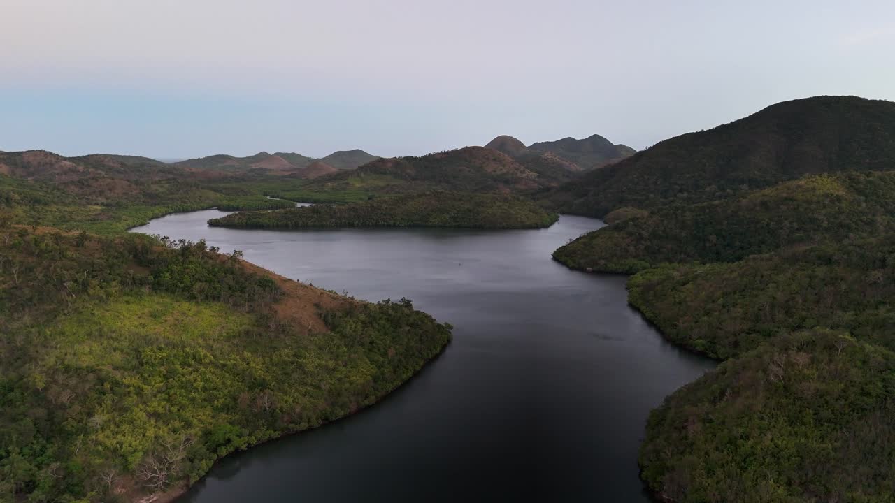 A quiet bay stretches between forested hills in Sitio Coring, Western Culion Island, Philippines, with calm waters and untouched greenery creating a peaceful and isolated natural environment
