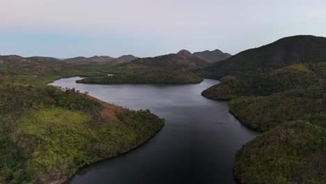 a quiet bay stretches between forested hills in sitio coring, western culion island, philippines, with calm waters and untouched greenery creating a peaceful and isolated natural environment