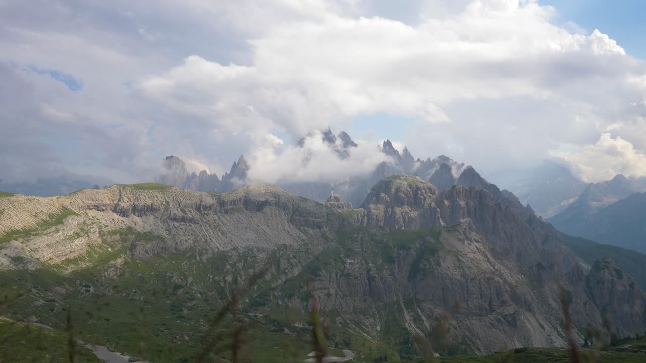 vista de las cimas de las montañas de los dolomitas en italia, con hierba tranquila ondeando en el viento