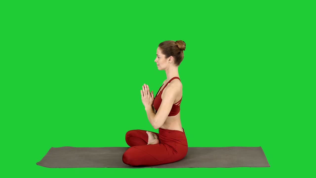 Jovem mulher atlética e atraente praticando yoga, fazendo a postura de Lótus em Tela Verde, Chroma Key