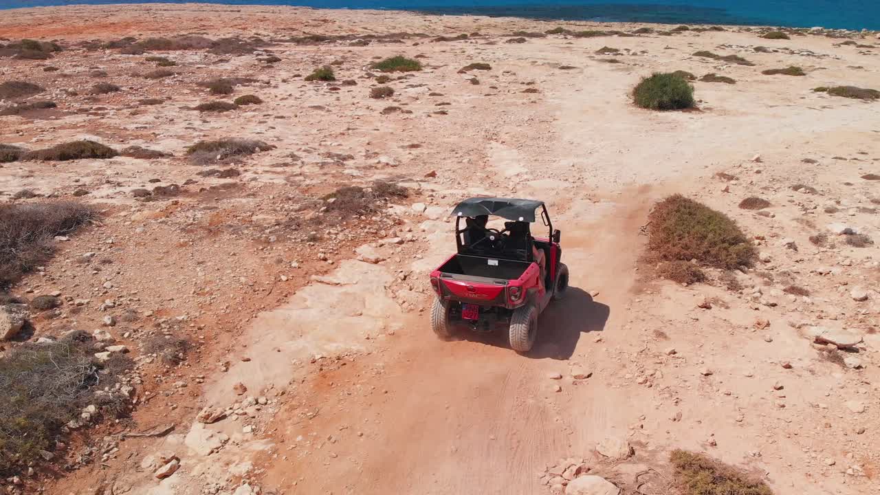 Una coppia sfreccia su un quad su terreno roccioso in fuoristrada.