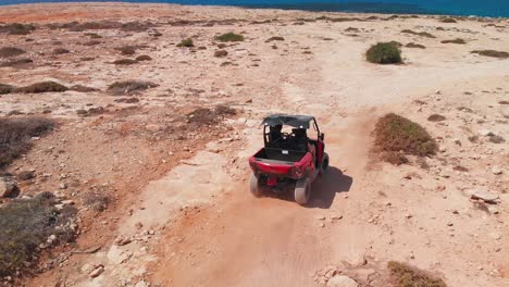 a couple speed off across rocky terrain in a four wheeler while off road