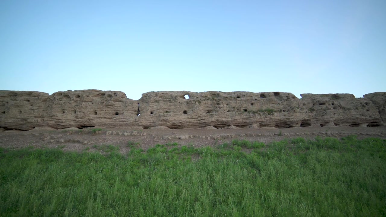 Ancient Earthen Wall Ruins Under Clear Blue Sky