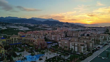 aerial drone forward moving shot over beautiful sunrise over the malaga city, andalusia, spain at dawn