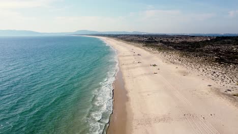 praia da comporta portugal, big beach with turquise water, big horizon, afternoon big dune, blue sky