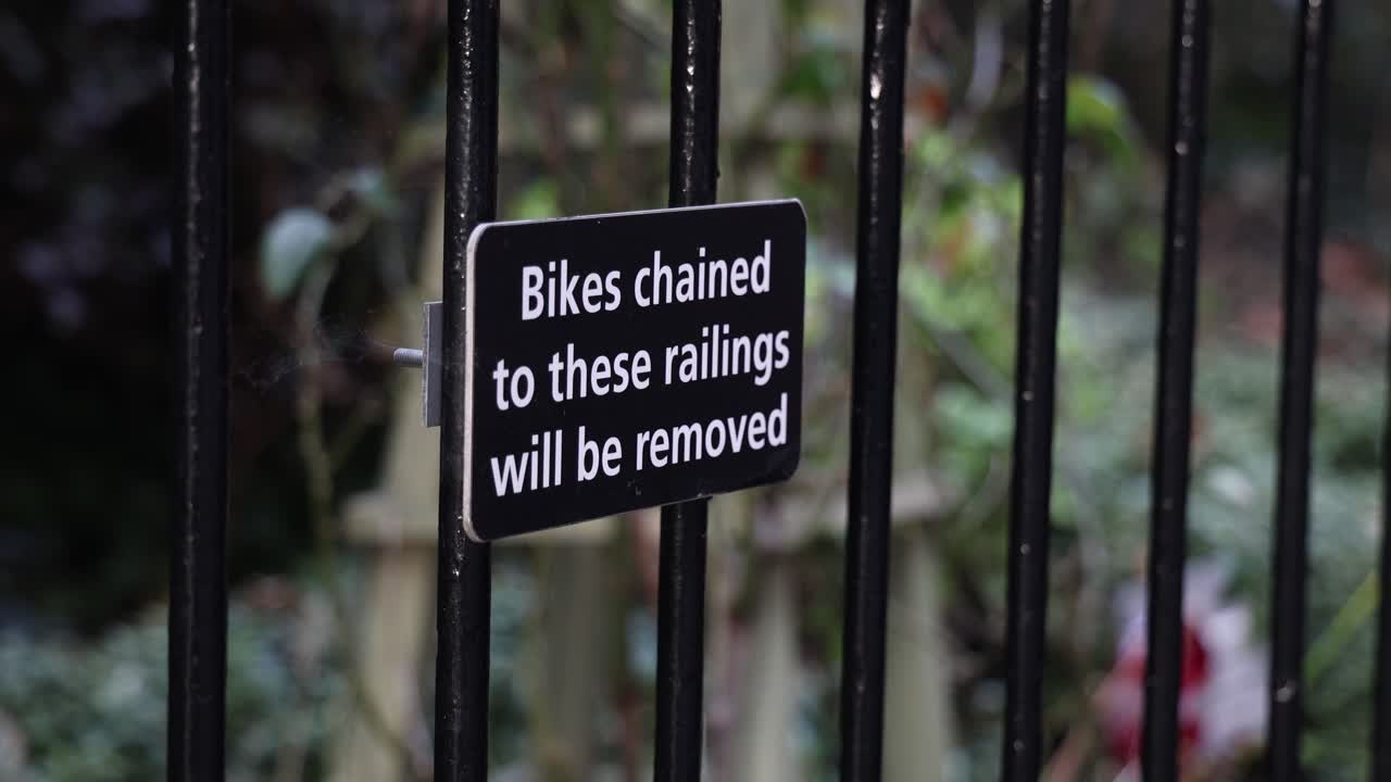 No bicycle parking sign on the metal fence