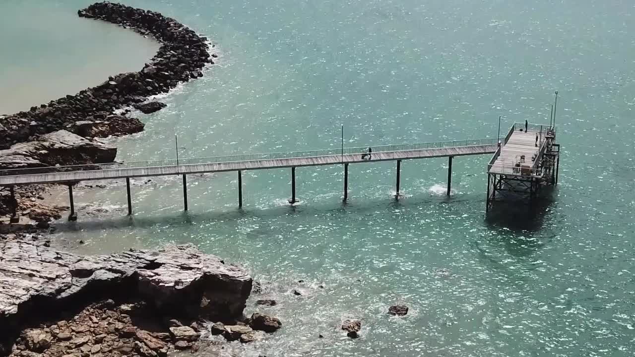 volando sobre el muelle de la playa de darwin cerca de los acantilados rocosos
