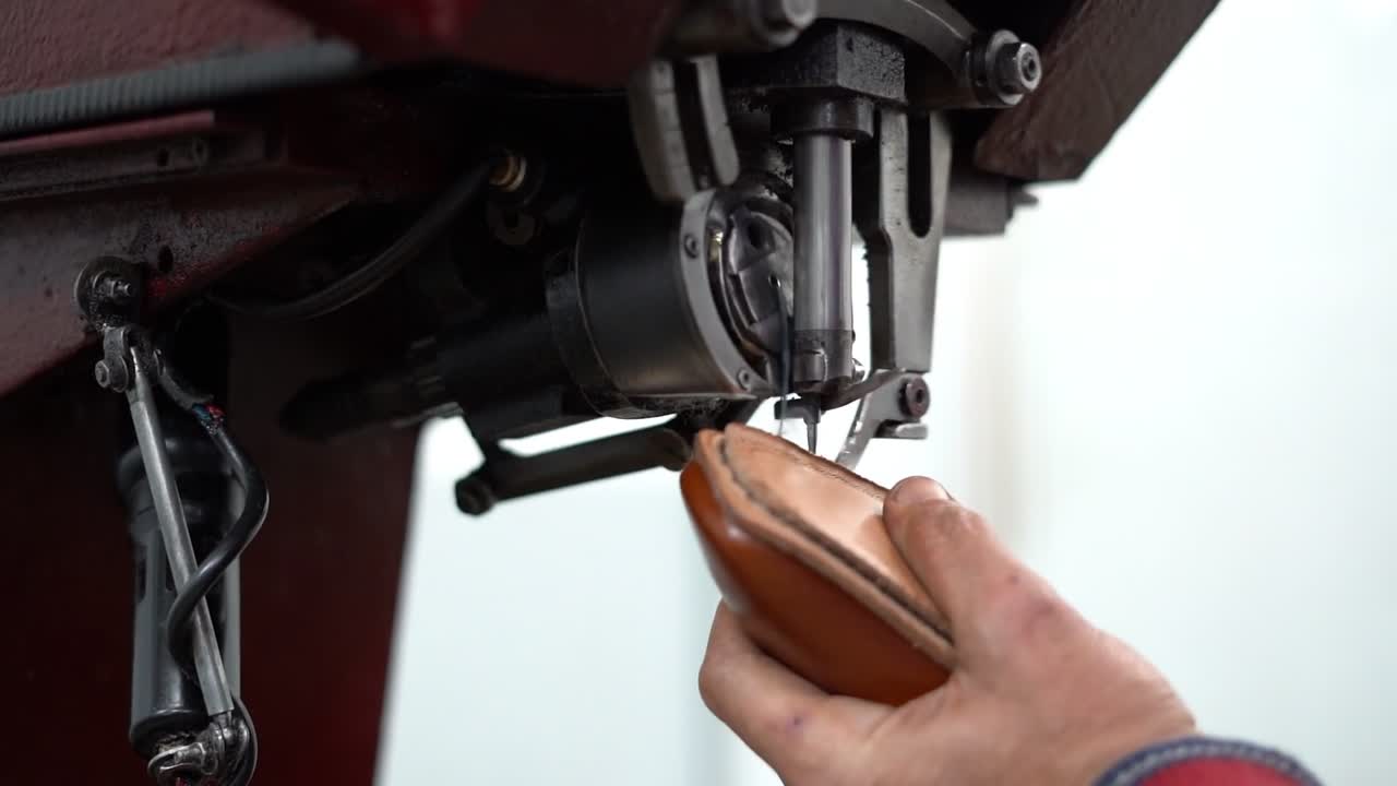 a craftsman handmade a shoe by a machine, close up shot, insert shot