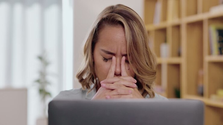 Kopfschmerzen, Stress und traurige Frau am Laptop